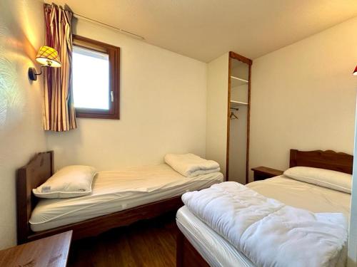 une chambre avec deux lits et une fenêtre dans l'établissement T3 6 personnes pied des piste, balcon 2 chambre separe a la semaine samedi au samedi, aux Orres