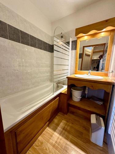 une salle de bain avec une baignoire, un lavabo et un miroir dans l'établissement T3 6 personnes pied des piste, balcon 2 chambre separe a la semaine samedi au samedi, aux Orres