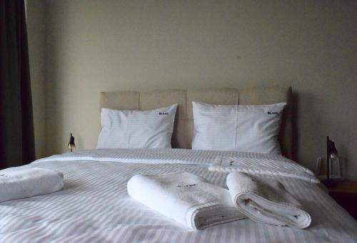 a white bed with towels and pillows on it at Blanc Apartments Zlatibor Center in Zlatibor