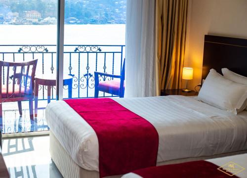 ein Hotelzimmer mit Bett und Balkon in der Unterkunft Hotel New Riviera bukavu in Bukavu