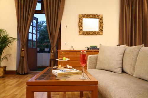 a living room with a couch and a table with a wine glass at Ambassador, New Delhi - IHCL SeleQtions in New Delhi