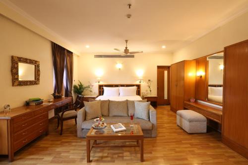 a hotel room with a bed and a couch and a table at Ambassador, New Delhi - IHCL SeleQtions in New Delhi