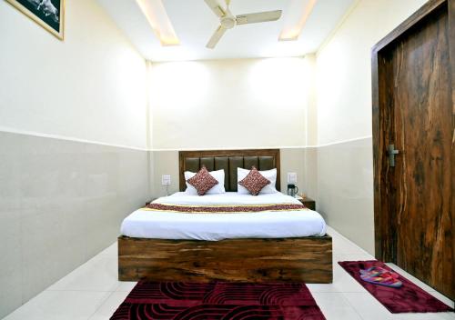 a bedroom with a large bed with a wooden headboard at Royal Inn Jammu in Jammu