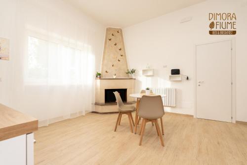 a living room with a table and chairs and a fireplace at Dimora Fiume - locazione turistica B&B in Gorgofreddo