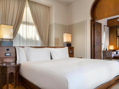 a bedroom with a large white bed and a window at Banyan Tree Tamouda Bay in Fnidek