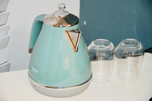 a blue electric kettle and two glasses on a counter at Melton Home Stay in Melton