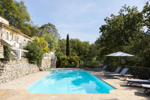 - une piscine dans une cour avec des chaises et un parasol dans l'établissement Magnifique villa 