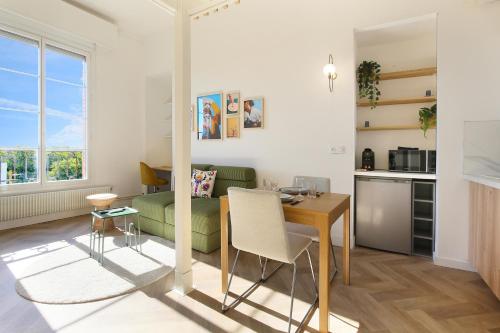 - un salon avec une table et un canapé vert dans l'établissement Vue imprenable et charme historique à Toulouse, à Toulouse