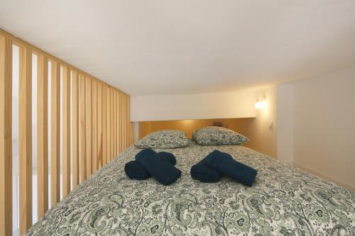 une chambre avec un lit avec deux oreillers bleus dans l'établissement Vue imprenable et charme historique à Toulouse, à Toulouse