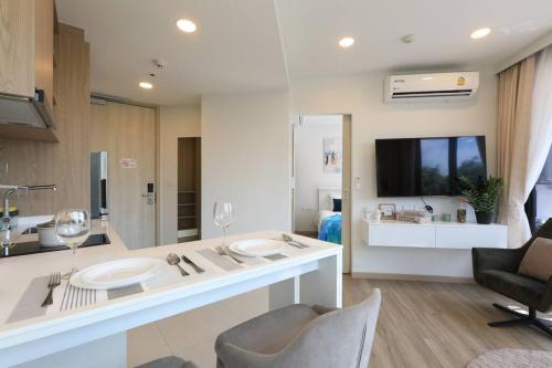 a kitchen and living room with a counter with two sinks at Sky Park condo 1 bedroom in Laguna Phuket