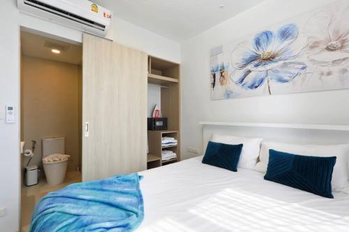 a bedroom with a white bed with blue pillows at Sky Park condo 1 bedroom in Laguna Phuket