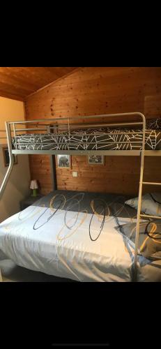 Ce lit superposé se trouve dans un dortoir doté d'un mur en bois. dans l'établissement Le chalet fleuri aux 4 saisons, à Cazilhac
