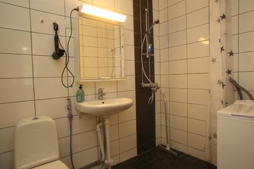 a bathroom with a sink and a toilet and a mirror at Kolmio Kokkola in Kokkola