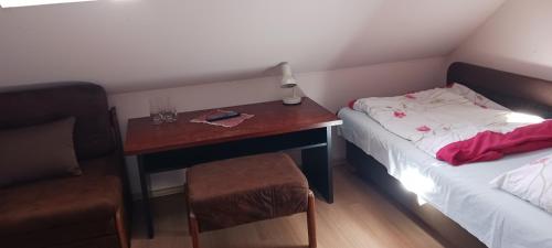 a small room with a desk and a bed and a chair at Central apartman in Nivy