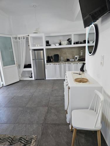a white kitchen with a white counter and a table at Eris Studios in Adamas