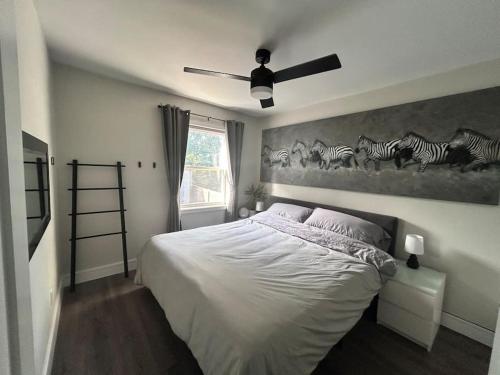 a bedroom with a bed and a painting of zebras at Lonborough Ave Upstairs in Toronto