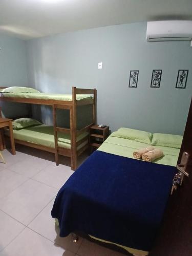 a bedroom with two bunk beds and a blue bed at Maga Inn House - Centro in Blumenau