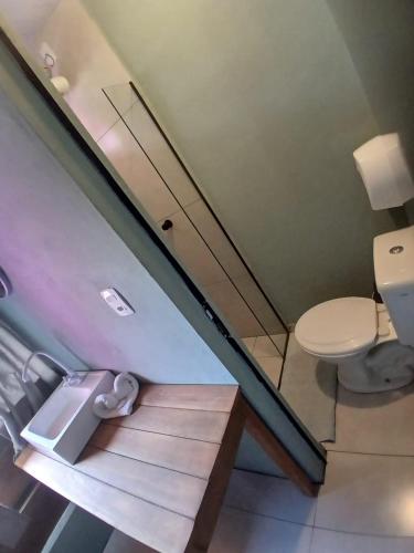 a bathroom with a toilet and a staircase at Maga Inn House - Centro in Blumenau