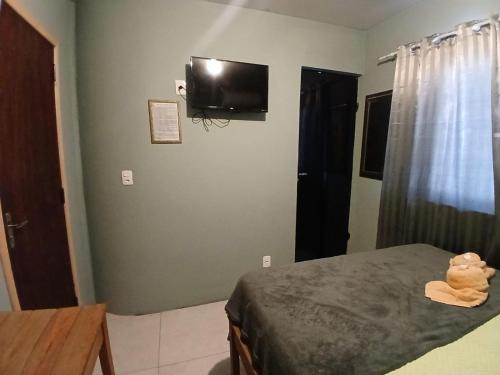 a teddy bear sitting on a bed in a bedroom at Maga Inn House - Centro in Blumenau