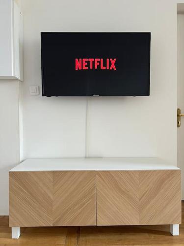 une télévision sur un mur blanc dans l'établissement Charmant F2 Plein centre de Mantes, à Mantes-la-Jolie