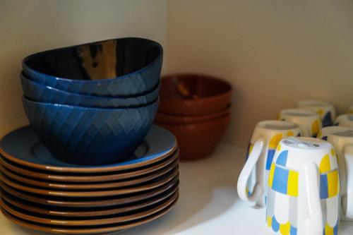 a stack of blue bowls and plates on a counter at Rest point cottage Kazbegi in Stepantsminda