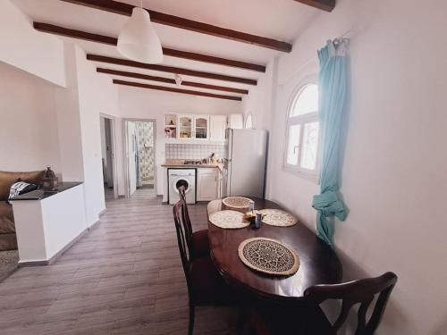 a kitchen with a wooden table and a dining room at Apartamento Esmeralda en Azotea in Tetouan