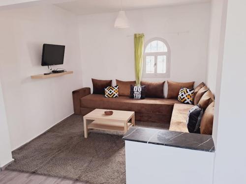a living room with a brown couch and a table at Apartamento Esmeralda en Azotea in Tetouan