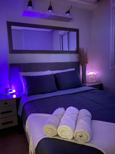 a bedroom with a bed with purple lights on it at Seu cantinho in Sao Paulo