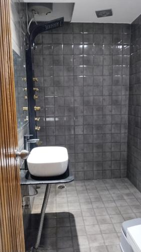 a bathroom with a sink and a tiled wall at Shashwat Resort in Gobindpur