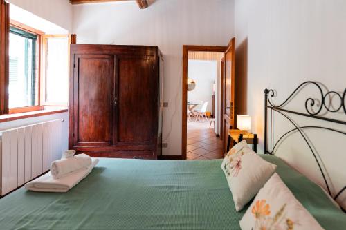 a bedroom with a green bed with a wooden cabinet at Agriturismo Casale le Crete in Acquapendente