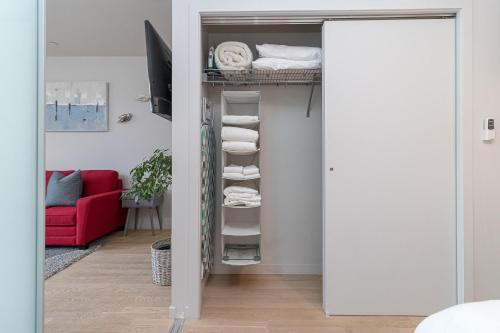 a door into a closet with a red couch at Sleek Kitchen Island And Garden Views in Victoria