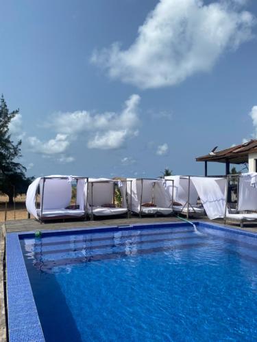 a swimming pool with lounge chairs and a swimming pool at Popbeachclub Suites ilashe in Ibasa