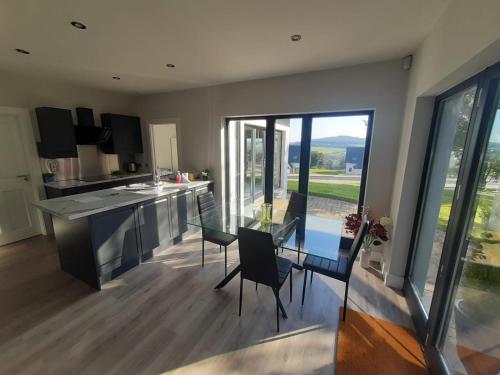 a kitchen and dining room with a table and chairs at Gorey Private Lodging & Holiday Mansion in Hollyfort