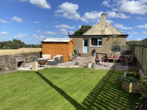 a small house with a yard with a lawn at 1 Inveravon Cottage in Falkirk