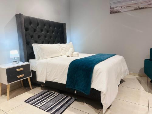 a bedroom with a large bed with a blue blanket at Royal Mansion Lodge in Johannesburg