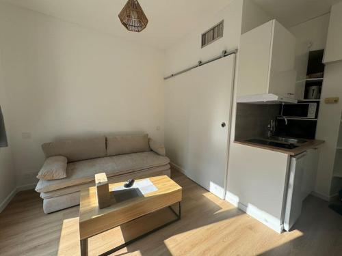 un salon avec un canapé et une table basse dans l'établissement Agréable Studio palais des congrès Porte Maillot, à Levallois-Perret