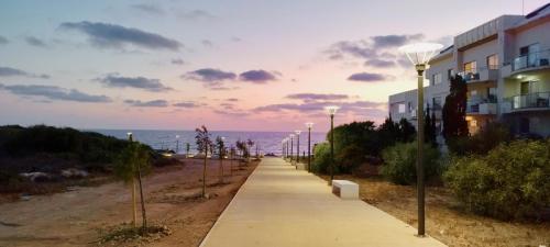 a sidewalk with street lights next to a building at Holiday House in Paphos Tomb of the Kings in Paphos City