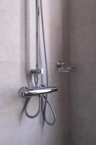 a shower with a shower head in a bathroom at Beachfront Villa Atalandia with Heated Pool, Gym, BBQ & Office in Goúdhouros