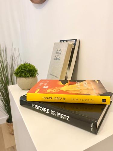 three books sitting on top of a table at Chic Nivoy Retreat, parking et gare à proximité in Pagny-sur-Moselle