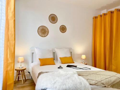 a bedroom with a white bed with orange curtains at Chic Nivoy Retreat, parking et gare à proximité in Pagny-sur-Moselle