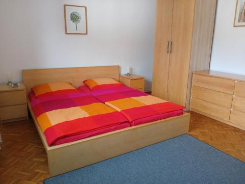 a bedroom with a bed with a colorful comforter at Ferienwohnungen Viersen in Viersen