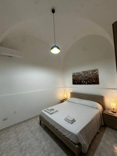 a bedroom with a bed and a pendant light at Casa Dafne di Palazzo Biondi in Giarre
