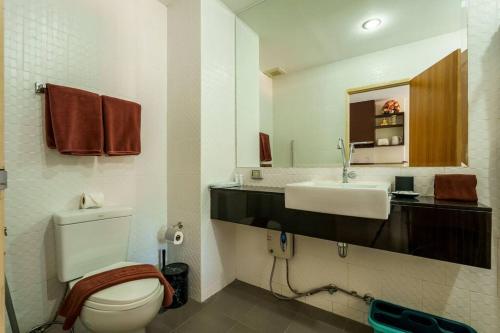 a bathroom with a toilet and a sink at Cosy 1 bedroom Chic condo in Karon Beach