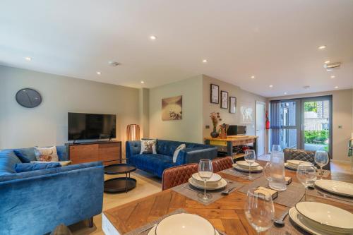 a living room with blue couches and a television at The Smelting Pot in Backbarrow