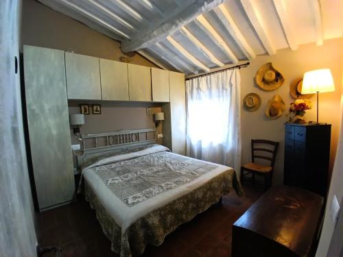 a bedroom with a bed and a window and a table at Borgo Cintoia casa per vacanze in Lucciano