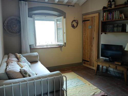 a living room with a couch and a television at Borgo Cintoia casa per vacanze in Lucciano