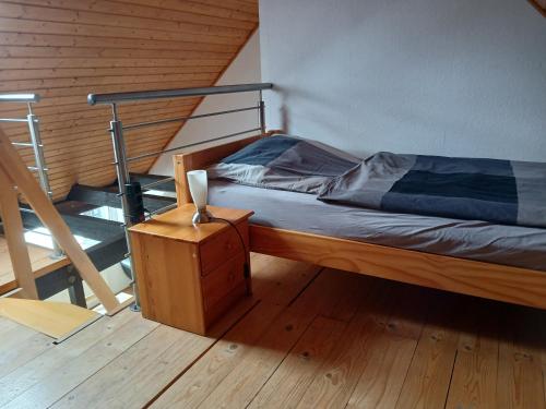 a bed in a room with a wooden floor at Ferienwohnungen Viersen in Viersen