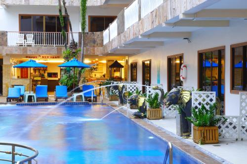 a pool in a hotel with blue chairs and umbrellas at Baan Boa Resort in Patong Beach