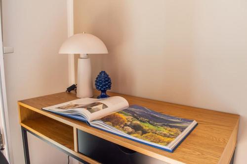 a table with a book and a lamp on it at Casa Martinèt- Prestogioso 2 suite 2 bagni privati con terrazza 35m in Bra