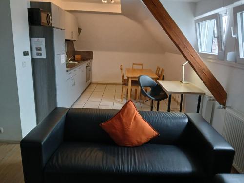 a living room with a black couch and a table at Ferienwohnungen Viersen in Viersen